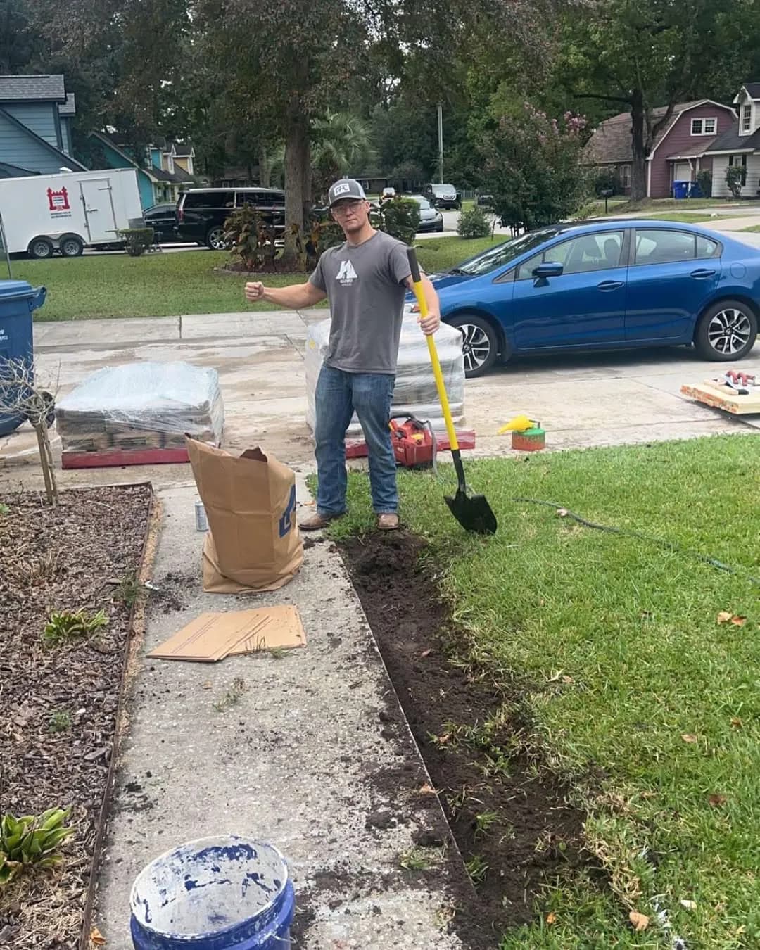 Worker demolishing old concrete walkway with shovel