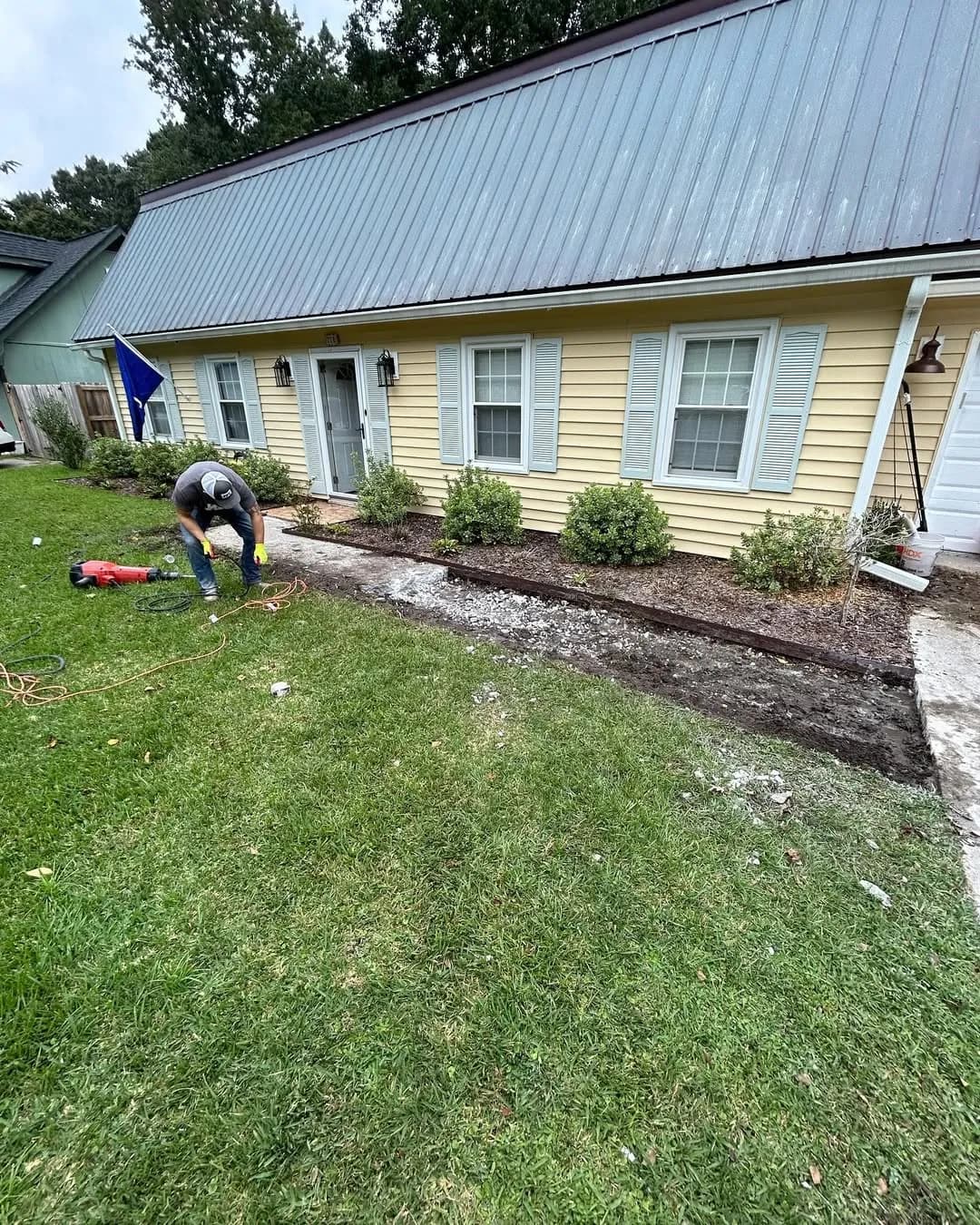 Worker excavating and preparing ground for new walkway