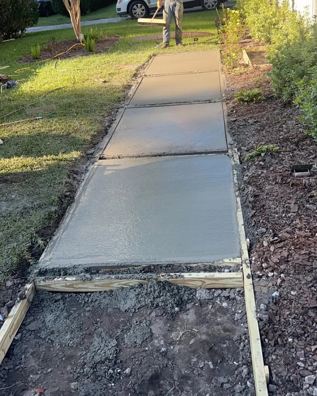 Freshly poured rectangular concrete pads with wooden forms in place