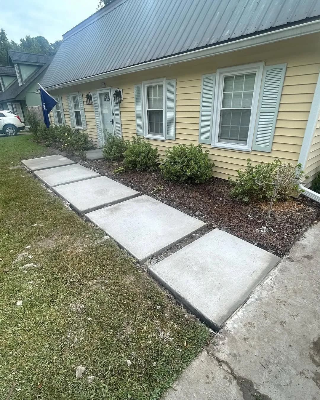 Concrete pads curing after form removal with gaps for gravel