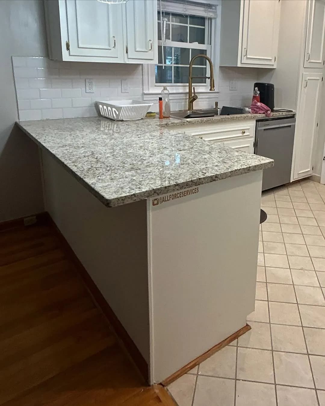 Finished kitchen peninsula with white cabinets granite countertops and subway tile backsplash
