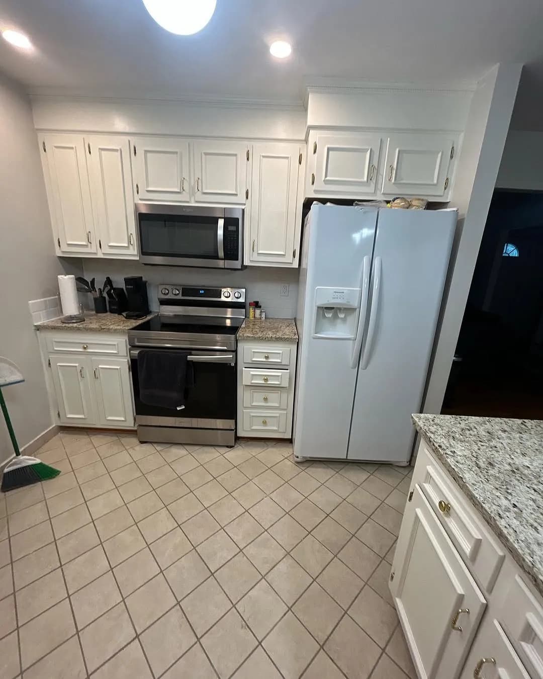 Finished kitchen wall with white cabinets stainless steel range and microwave