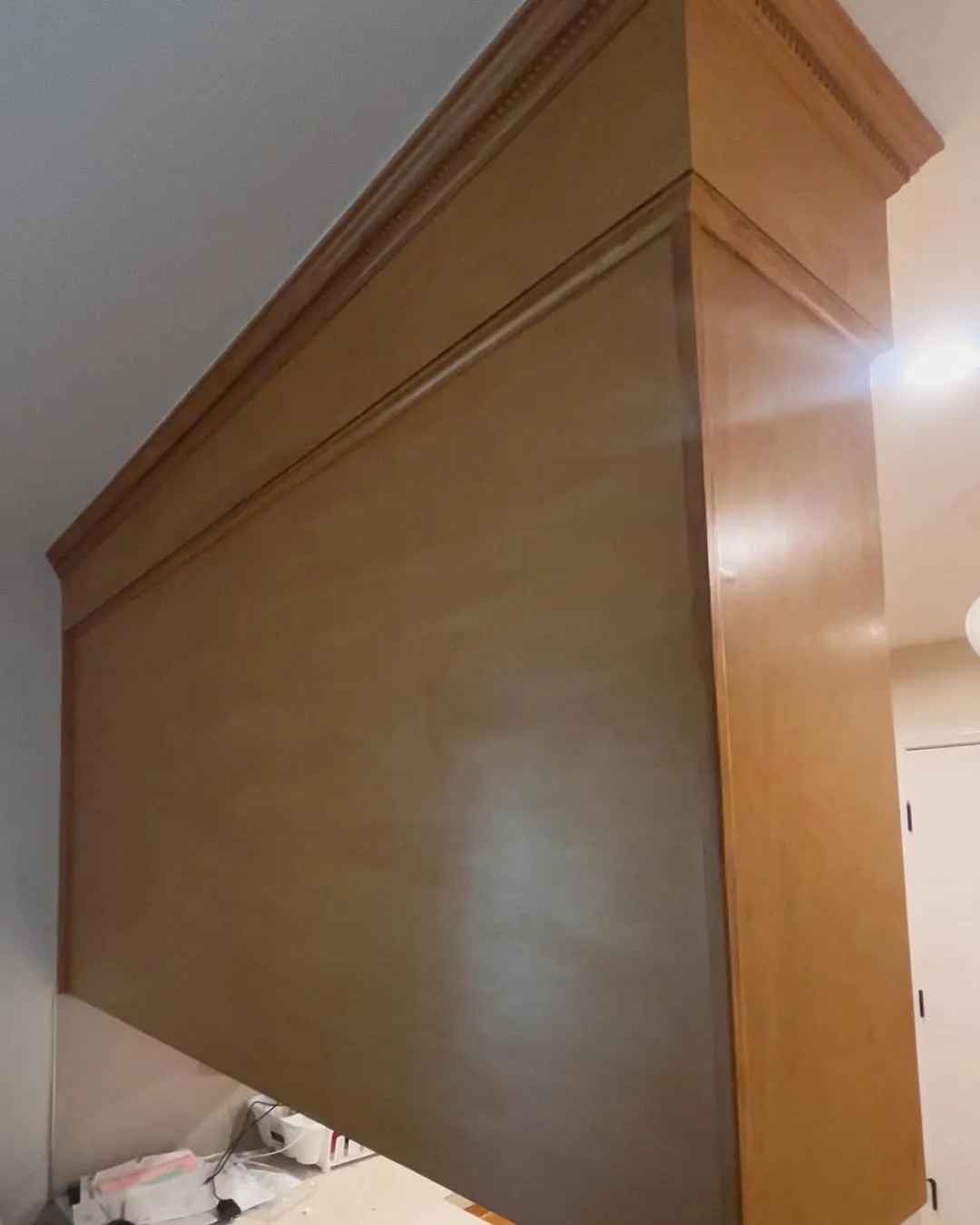 Large overhead cabinet structure hanging above the kitchen peninsula