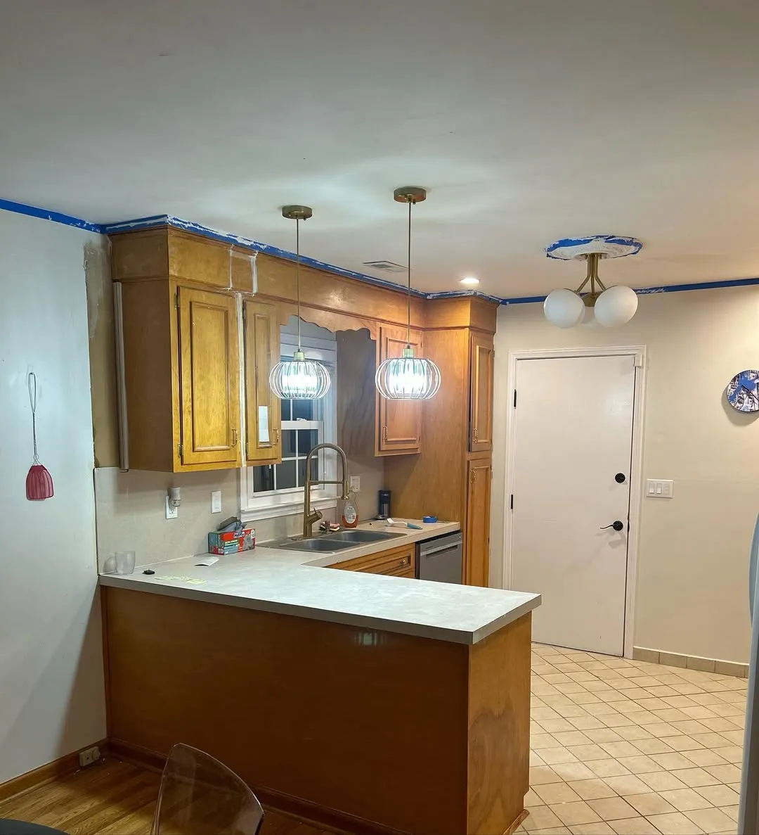 New pendant lights installed and granite countertops in place with cabinets still unpainted