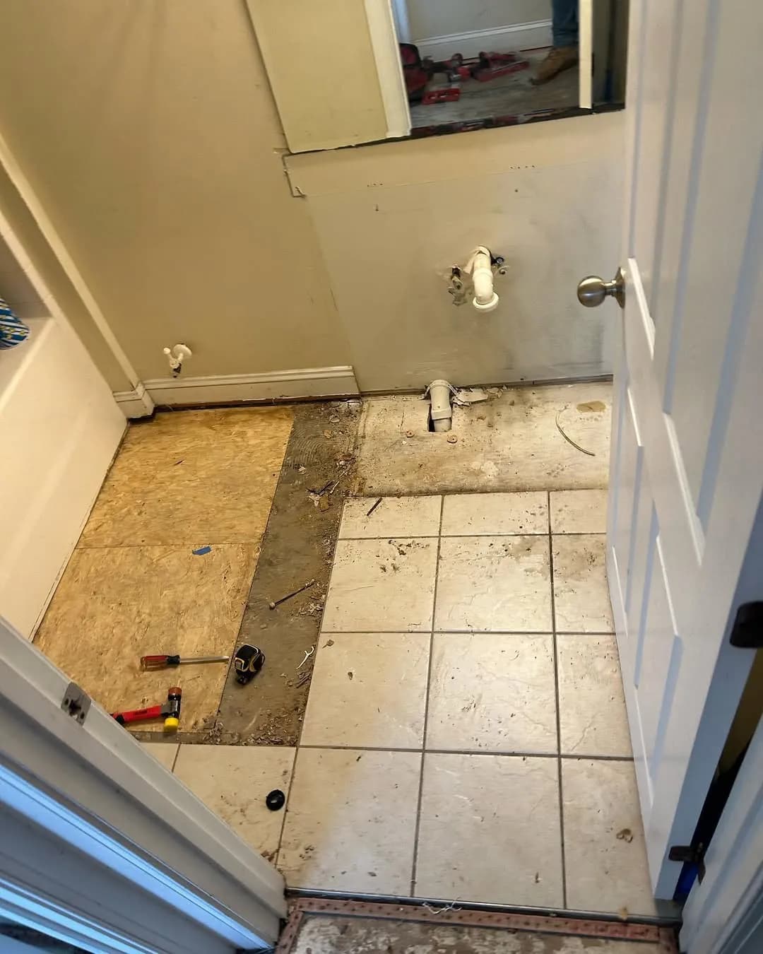 Vanity and toilet removed with exposed plumbing supply lines